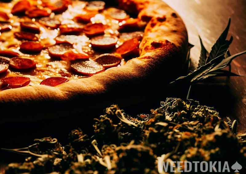 Pizza next to weed on a table