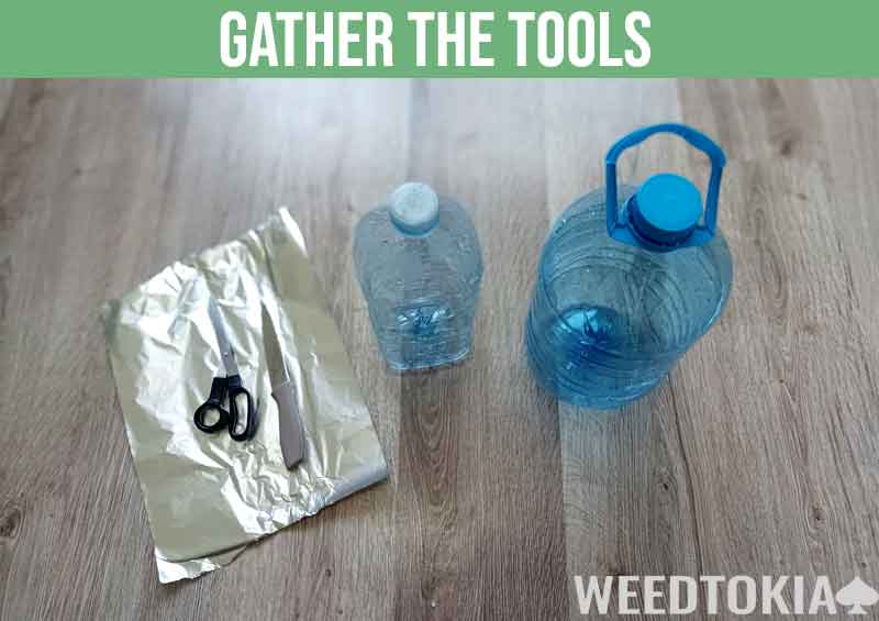 Tools needed to make a Gravity Bong at home (bottles, cutting tools, and folio)