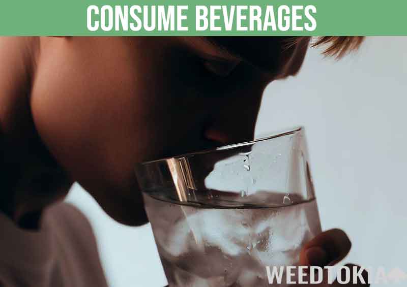 Young guy drinking an icy glass of water