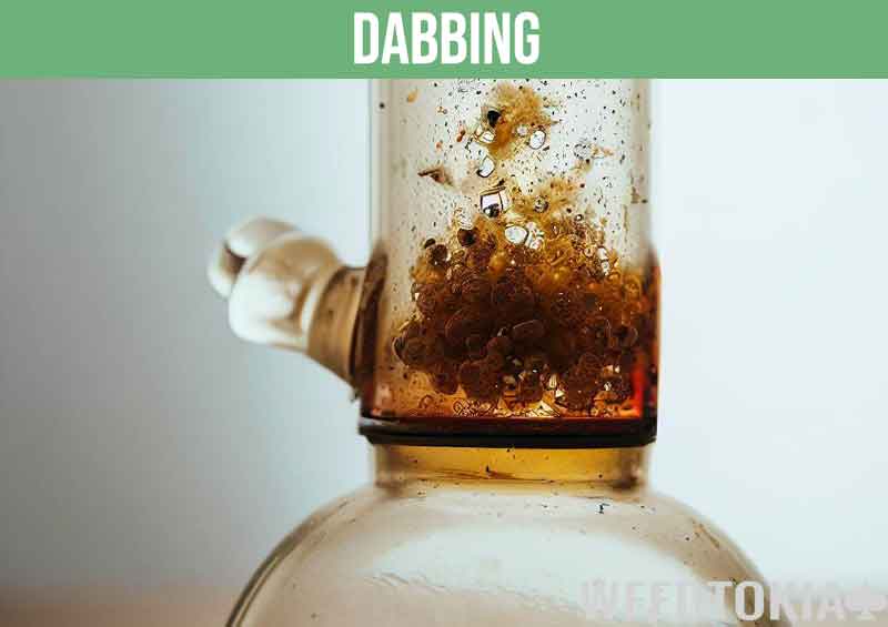 Dabbing weed concentrates in a glass Dab Rig